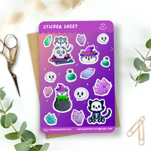 May include: A sticker sheet with a purple background featuring a variety of Halloween-themed illustrations. The illustrations include a wolf wearing a witch's hat, a cauldron with green liquid, a skull, crystals, and a skeleton cat. The text "STICKER SHEET" is at the top of the sheet.