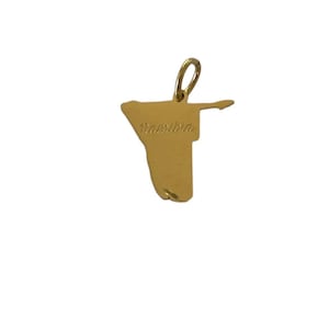 May include: A gold-colored pendant in the shape of Namibia, with the country's name inscribed in a cursive font. The pendant has a loop at the top for a chain.