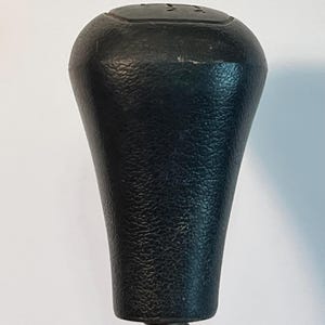 May include: A set of three ceramic mugs with a speckled, matte finish. The mugs are in shades of cream, light gray, and dark gray. Each mug has a simple, minimalist design and a rounded handle.