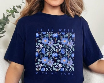 May include: A navy blue t-shirt with a floral print and the text "It is well with my soul".