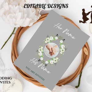 Puede incluir: Una invitación de boda gris con el texto "Her Name" y "His Name". La invitación presenta una foto de dos manos con un anillo, rodeada por una corona floral. Las palabras "You are invited" también están en la invitación. Las palabras "Editable Designs" y "Wedding Invites" también están en la imagen.