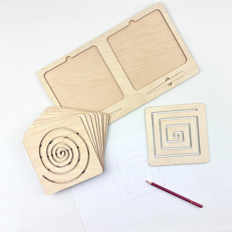 May include: A set of wooden tracing templates featuring a spiral design. The set includes a large template with two sections, a smaller square template, and a sheet of paper with a pencil for tracing.