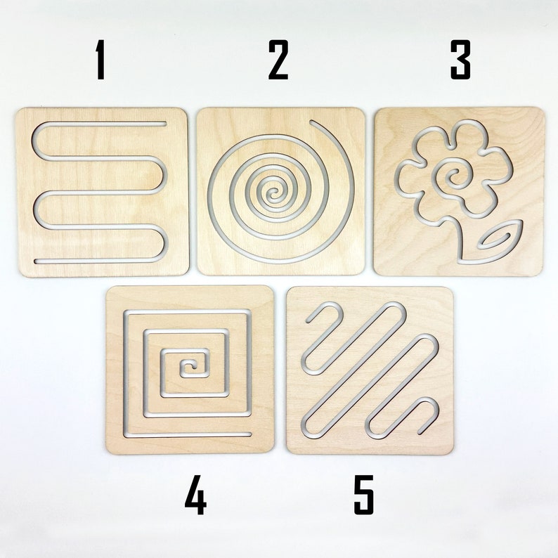 May include: Five wooden tracing boards with different patterns, numbered 1 through 5. The patterns include a wavy line, a spiral, a flower, a square with concentric squares, and diagonal lines.