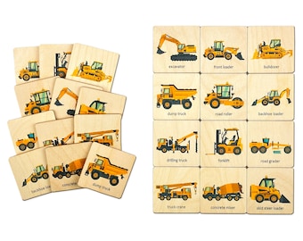 May include: Wooden construction vehicle flashcards. Each card features a yellow vehicle illustration and its name, including excavator, dump truck, and concrete mixer. The cards are arranged in a pile and in a grid.