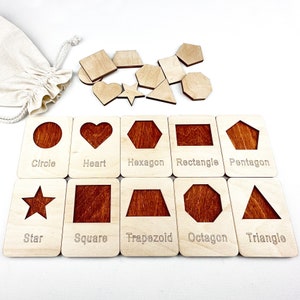 May include: Wooden puzzle pieces with different shapes, including a circle, heart, hexagon, rectangle, pentagon, star, square, trapezoid, octagon, and triangle. Each shape is labeled with its name.