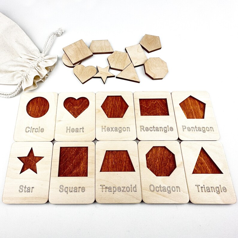 May include: Wooden puzzle pieces with different shapes, including a circle, heart, hexagon, rectangle, pentagon, star, square, trapezoid, octagon, and triangle. Each shape is labeled with its name.