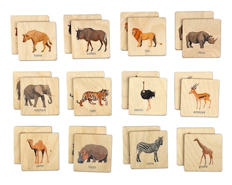 May include: A set of 12 wooden tiles featuring illustrations of different animals, each with the animal's name printed below. The animals include a hyena, buffalo, lion, rhino, elephant, tiger, ostrich, antelope, camel, hippo, zebra, and giraffe.