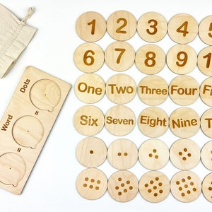 May include: Wooden learning toy with 10 round pieces featuring numbers 1-10, words one to ten, and corresponding dots. The toy also includes a wooden board with slots for number, word, and dots.