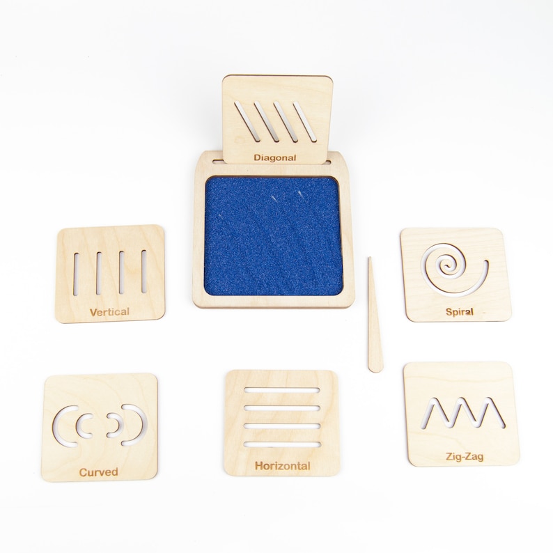 May include: Wooden tracing board with a blue felt surface and six different wooden tiles with various line patterns: diagonal, vertical, spiral, curved, horizontal, and zig-zag. Each tile has a label with the corresponding line pattern name.