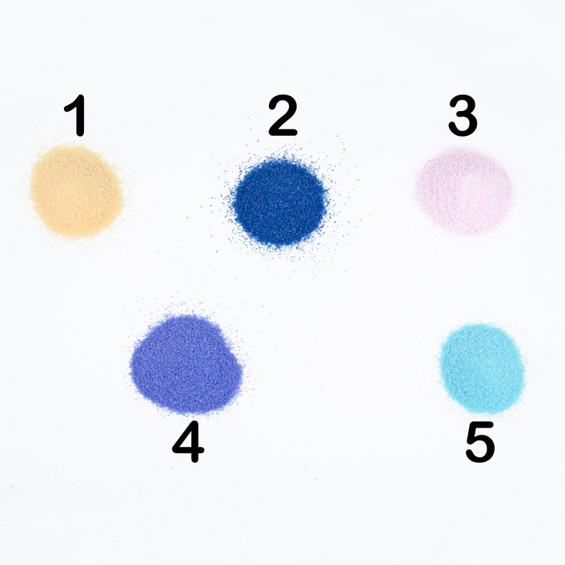 May include: Five small piles of colored sand, numbered 1 through 5. The sand is in the following colors: beige, blue, pink, purple, and light blue.