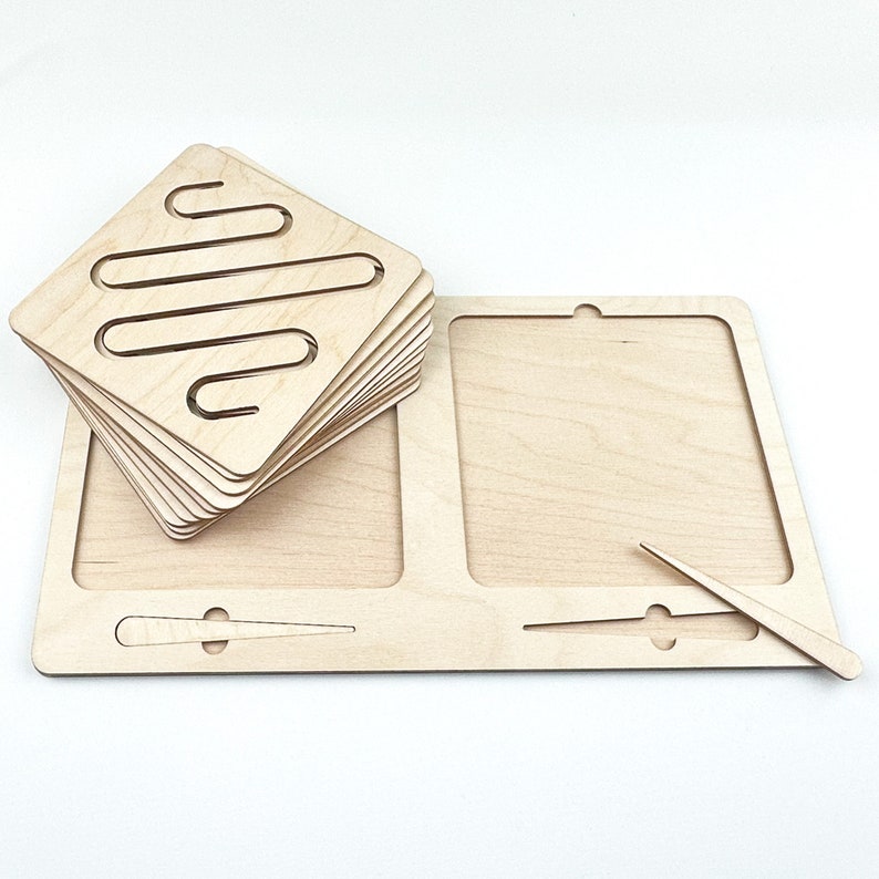 May include: A wooden toy with a set of interchangeable square puzzle pieces with a maze pattern. The puzzle pieces are stacked on top of each other. The toy also includes a wooden base with a larger square space and a smaller rectangular space. A wooden stick is included to help move the puzzle pieces.
