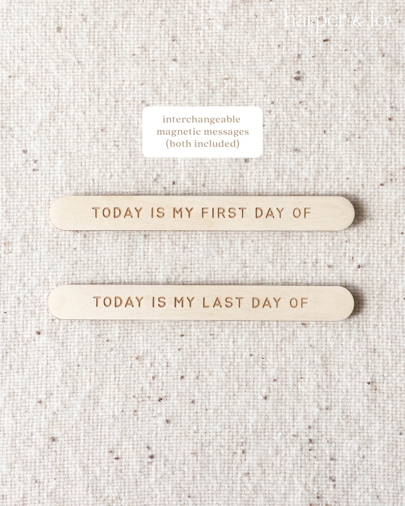 May include: Two wooden signs with the text "TODAY IS MY FIRST DAY OF" and "TODAY IS MY LAST DAY OF" on a beige fabric background. The signs are interchangeable and magnetic.