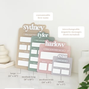 May include: Four different sizes of personalized baby milestone boards. The boards are beige, green, pink, and gray. Each board has a space for a name, date, and other milestones. The boards are 11 inches by 12 inches, 8 inches by 10 inches, 10 inches by 8 inches, and 6 inches by 5 inches.