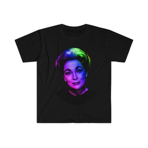 Pode incluir: Uma camiseta preta com uma imagem colorida de uma mulher com um penteado arco-íris. A mulher está olhando para o espectador com um leve sorriso.
