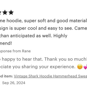 May include: Five star review for a vintage shark hoodie sweatshirt. The review states that the hoodie is super soft and the design is cool and easy to see. The reviewer also states that the hoodie arrived earlier than expected.