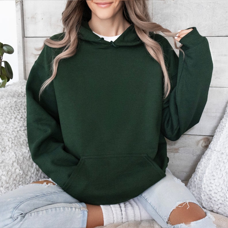 May include: A dark green hooded sweatshirt with a kangaroo pocket.