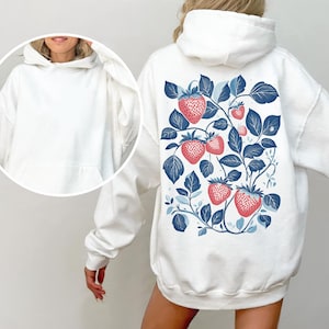 May include: White hoodie with a blue and red strawberry print on the back. The strawberries are arranged on a vine with leaves.