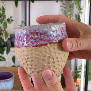 May include: A white ceramic mug with a black handle and the text "But First, Coffee" in a black, bold font. The mug is on a white surface.