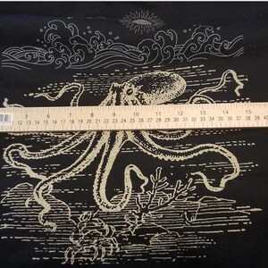 May include: Black t-shirt with a white graphic of an octopus with tentacles and waves. The octopus is surrounded by a white border.