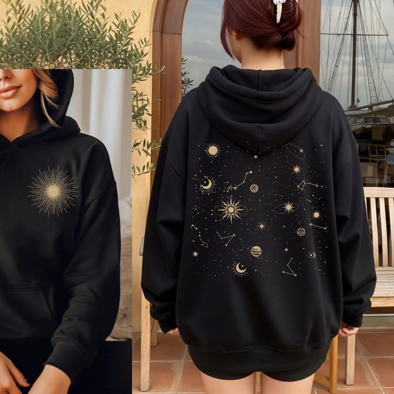 May include: Black hoodie with a gold sunburst design on the front and a celestial pattern on the back. The design includes suns, moons, stars, and constellations. The hoodie has a hood and a kangaroo pocket.