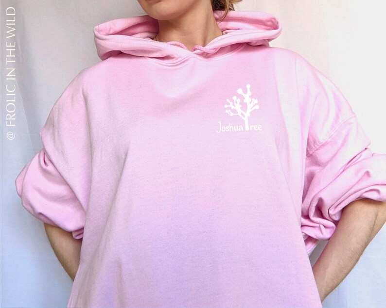 May include: A pink oversized hoodie with a white graphic of a Joshua Tree and the text "Joshua Tree" on the front.