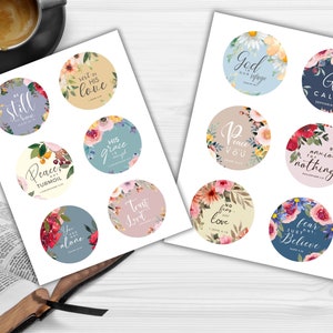 May include: Two sheets of circular stickers with floral designs and inspirational quotes. The stickers feature phrases like "Be Still," "Rest in His Love," and "God is our refuge." The stickers are surrounded by colorful floral arrangements.