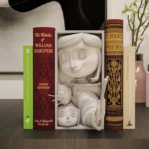 May include: A decorative bookend featuring a sculpted figure with a cat, flanked by classic literature. The books include "The Works of William Shakspere" and "Hemans Poems". The color palette includes red, green, and brown tones.