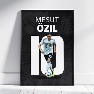 May include: A black and white poster with a photo of Mesut Özil, a German soccer player, wearing a white jersey with the number 10 on it. The poster has the text "Mesut Özil 10" in white letters.