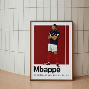 K&ouml;nnte beinhalten: Ein gerahmtes Poster mit einem Fu&szlig;ballspieler in einem dunkelblauen Trikot und wei&szlig;en Shorts mit der Nummer 10 vor einem tiefroten Hintergrund. Der Text Mbapp&eacute; ist darunter gedruckt, gefolgt von einer Liste der Erfolge und Statistiken.