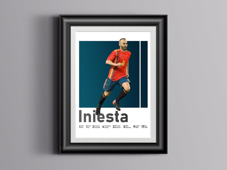 K&ouml;nnte beinhalten: Ein gerahmtes Poster mit einem Fu&szlig;ballspieler in einem rot-gelben Trikot, unter dem der Name "Iniesta" steht. Der Spieler ist in der Luft und tritt einen Fu&szlig;ball. Das Poster enth&auml;lt auch eine Liste der Leistungen des Spielers, darunter 1 Weltmeisterschaft, 2 Europameisterschaften, 4 La Liga-Titel, 3 Champions League-Titel, 9 spanische Supercups und 17 Troph&auml;en.