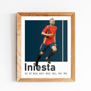 K&ouml;nnte beinhalten: Ein gerahmtes Poster mit einem Foto eines Fu&szlig;ballspielers in einem rot-gelben Trikot, der mit dem Ball l&auml;uft. Der Name des Spielers, "Iniesta", ist in fetten schwarzen Buchstaben unter dem Foto gedruckt. Das Poster enth&auml;lt auch eine Liste der Erfolge des Spielers, darunter 1 Weltmeisterschaft, 2 Europameisterschaften, 4 Champions-League-Titel, 3 FIFA-Klub-Weltmeistertitel, 9 La-Liga-Titel und 17 Copa-del-Rey-Titel.