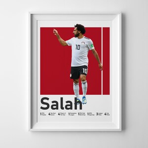 K&ouml;nnte beinhalten: Ein rot-wei&szlig;es Poster mit einem Foto eines Fu&szlig;ballspielers, der ein wei&szlig;es Trikot mit der Nummer 10 tr&auml;gt. Der Spieler ist in der Luft und tritt einen Fu&szlig;ball. Das Poster tr&auml;gt den Text "Salah" in gro&szlig;en schwarzen Buchstaben unten. Unter dem Namen stehen die W&ouml;rter "FIFA Puskas", "Top-Torsch&uuml;tze", "Spieler des Jahres", "UEFA Champions League", "FIFA Club World Cup", "UEFA Super Cup", "Liga-Titel", "Pokal-Titel" und Zahlen, die angeben, wie oft der Spieler jeden Preis gewonnen hat.