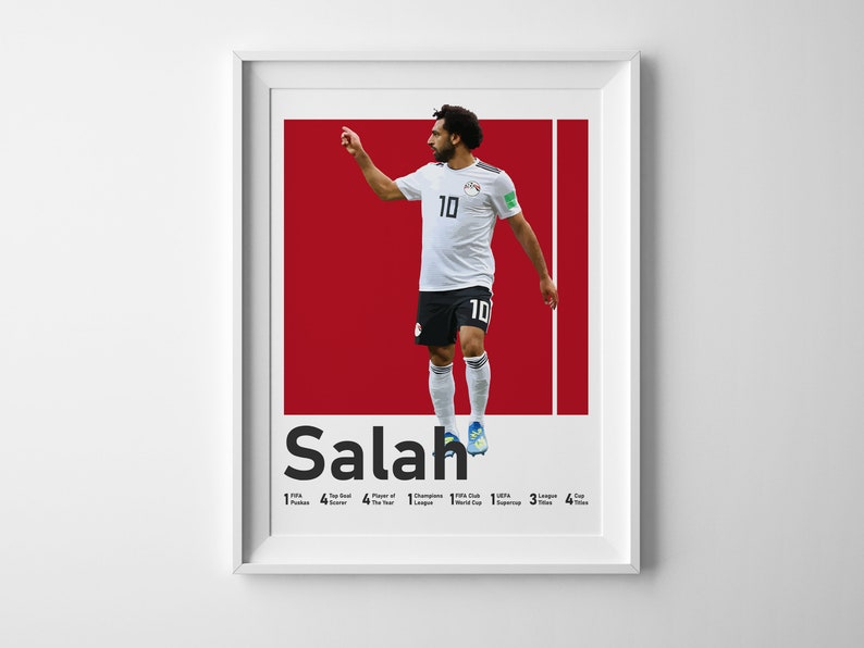 K&ouml;nnte beinhalten: Ein rot-wei&szlig;es Poster mit einem Foto eines Fu&szlig;ballspielers, der ein wei&szlig;es Trikot mit der Nummer 10 tr&auml;gt. Der Spieler ist in der Luft und tritt einen Fu&szlig;ball. Das Poster tr&auml;gt den Text "Salah" in gro&szlig;en schwarzen Buchstaben unten. Unter dem Namen stehen die W&ouml;rter "FIFA Puskas", "Top-Torsch&uuml;tze", "Spieler des Jahres", "UEFA Champions League", "FIFA Club World Cup", "UEFA Super Cup", "Liga-Titel", "Pokal-Titel" und Zahlen, die angeben, wie oft der Spieler jeden Preis gewonnen hat.