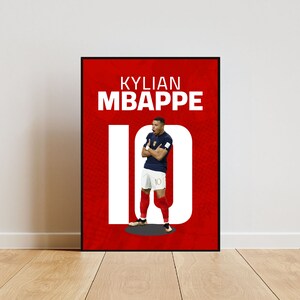 以下が含まれることがあります： 白と赤のポスターに、白い文字で「KYLIAN MBAPPE 10」と書かれている。ポスターの中央には、青いユニフォームを着て背番号10のサッカー選手の画像が掲載されている。