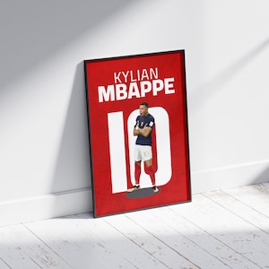 以下が含まれることがあります： 赤い背景に白い文字で「Kylian Mbappe 10」と書かれた額縁付きポスター。ポスターの中央には、青いユニフォームを着て背番号10のサッカー選手の画像が写っている。