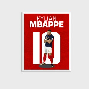 以下が含まれることがあります： 赤と白のポスターに「KYLIAN MBAPPE」の文字と大きな白いフォントで「10」の数字が書かれています。ポスターの中央には、青と白のジャージを着て背番号「10」をつけたサッカー選手の画像があります。