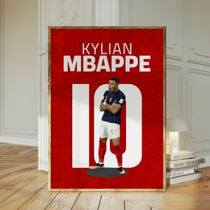以下が含まれることがあります： 白い数字の10と白い文字で「KYLIAN MBAPPE」と書かれた赤いポスター。青いユニフォームを着て背番号10のサッカー選手の画像がポスターの中央に配置されている。