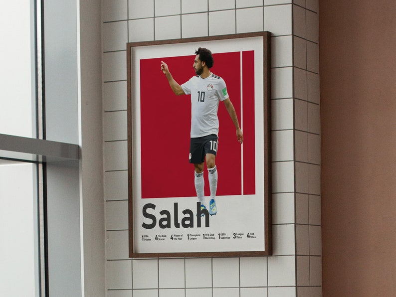 K&ouml;nnte beinhalten: Ein Poster mit einem Foto von Mohamed Salah, einem professionellen Fu&szlig;ballspieler, der ein wei&szlig;es Trikot mit der Nummer 10 tr&auml;gt. Der Hintergrund ist rot und der Text "Salah" ist in Schwarz unter dem Foto gedruckt. Das Poster enth&auml;lt auch eine Liste von Salahs Leistungen, darunter "1 Premier League", "4 Champions League", "1 FIFA Club World Cup", "3 Super Cup" und "4 Africa Cup of Nations".
