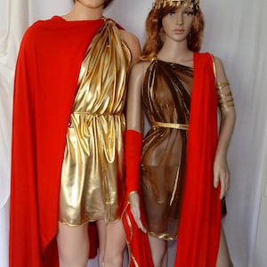 May include: Two gold and red costumes with leaf headbands. The costumes are made of shiny fabric and have a draped style.