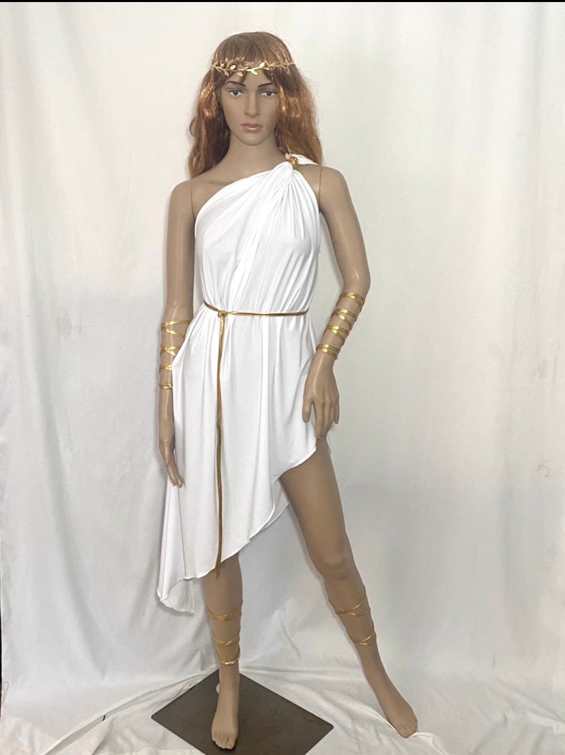 White asymmetrical toga dress with gold belt, gold shoulder tie, 2 gold snake like arm/leg wraps and gold leaf crown.
Toga has on exposed shoulder and goes down on one side to mid calf