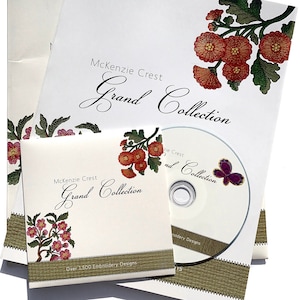 May include: A collection of embroidery design materials, including a CD and several white paper sleeves. The sleeves and CD case feature floral designs in red and green, with the text "McKenzie Crest Grand Collection". The CD has a purple butterfly.