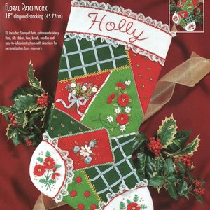 May include: A Bucilla felt applique stocking kit with silk embroidery. The stocking is 18 inches long and features a patchwork design with red, green, and white felt pieces. The stocking is decorated with embroidered flowers and a holly sprig. The kit includes all the materials needed to complete the stocking, including felt, embroidery floss, silk ribbon, lace, beads, needles, and instructions.