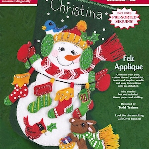 May include: A green felt Christmas stocking craft kit by FeltWorks featuring a snowman with a blue bird, red mittens, and small stockings. The package text indicates it is 18 inches long, includes pre-sorted sequins, and contains wool yarn, cotton thread, printed felt, beads, and a needle.