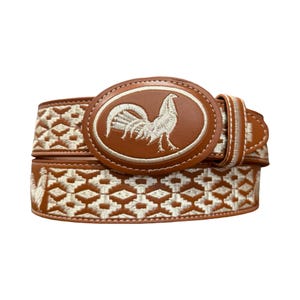 May include: A brown belt featuring a large oval buckle with an embroidered white rooster design. The belt strap is decorated with a repeating white geometric diamond pattern and includes an additional embroidered rooster on the side.
