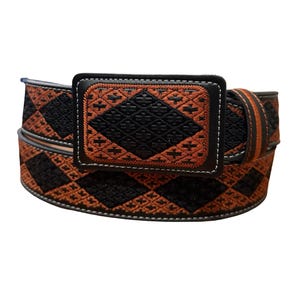 May include: A belt featuring a repeating diamond pattern in black and burnt orange embroidery. The rectangular buckle is covered in matching black and orange embroidered fabric with a stitched border, and the belt edges are finished with white stitching.