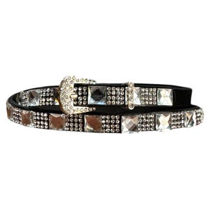 May include: A black leather belt with a silver buckle and clear rhinestone embellishments.