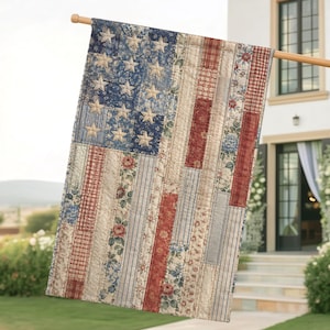 May include: A rectangular garden flag featuring a patchwork design of the American flag. The canton is blue with cream-colored stars, while the stripes are composed of vertical fabric panels in red, white, and blue with floral and plaid patterns.