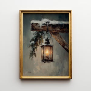 May include: A framed painting shows a lantern suspended from a snow-covered wooden beam. The lantern, with a lit candle inside, hangs by a metal hook. Snow-covered evergreen branches are on the left. The painting is in a gold frame.