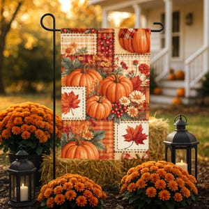 May include: A rectangular garden flag featuring a patchwork design of orange pumpkins, red maple leaves, white and yellow chrysanthemums, and red berries. The pattern includes sections of plaid and checkered fabric in warm autumn colors.
