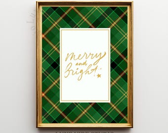 May include: A framed print with a gold border features a green and black plaid pattern. The center has a white rectangle with the gold text "merry and bright" and a star. The bottom right corner has the text "LUXE VIBE STUDIO".